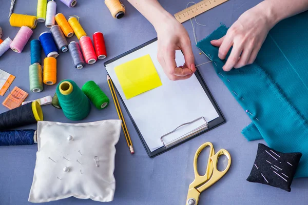 Kadın terzi dikiş dikmek için dikiş dikiyor.