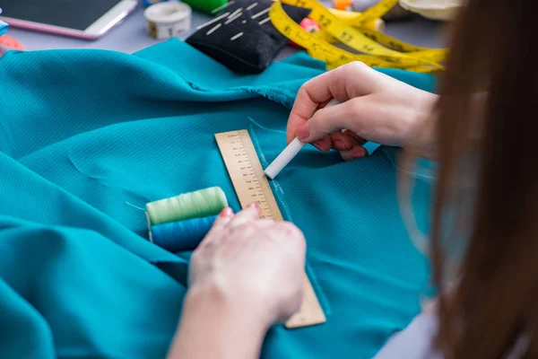 Kadın terzi dikiş dikmek için dikiş dikiyor.