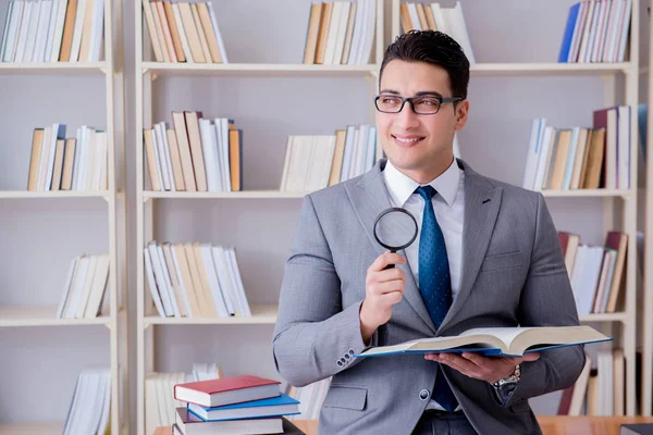 Büyüteçle hukuk fakültesi öğrencisi kitap okuyor.