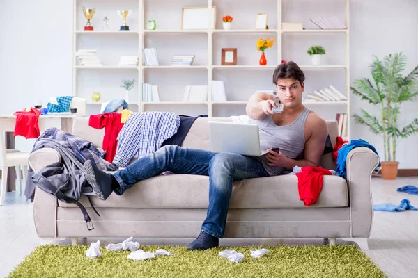 Jongeman aan het werk in rommelige kamer — Stockfoto