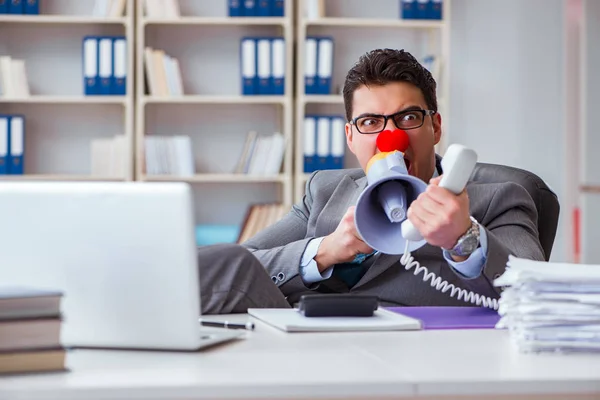 Clown affärsman arg på kontoret med en megafon — Stockfoto