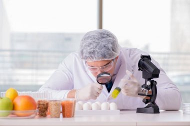 Besin uzmanı gıda ürünlerini laboratuarda test ediyor.