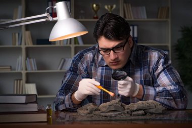 Arkeolog geç saatlere kadar ofiste çalışıyor.