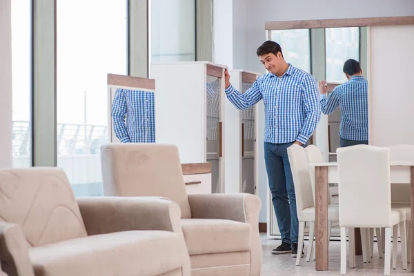 Genç adam mobilya dükkanından alışveriş yapıyor.