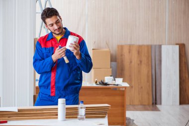 Yooung marangoz boyayla uğraşıyor.