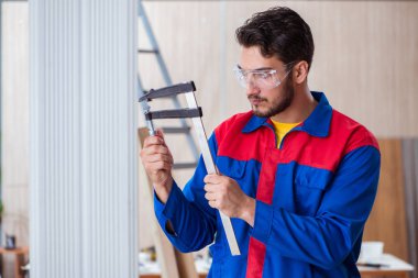 Klemplerle çalışan genç bir tamirci.