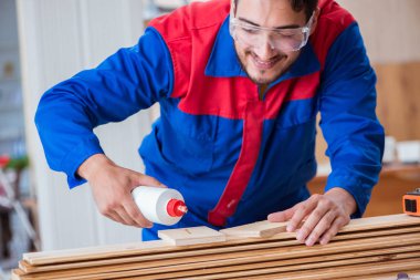 Yooung marangoz boyayla uğraşıyor.