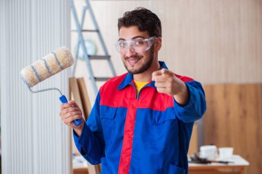 Yooung marangoz boyayla uğraşıyor.