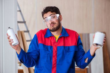 Yooung marangoz boyayla uğraşıyor.