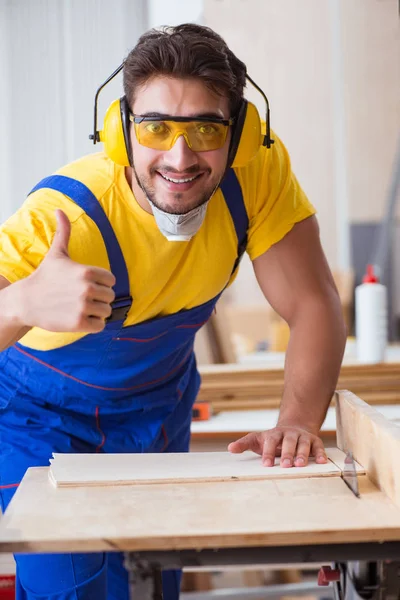 Jeune menuisier réparateur travaillant le bois de coupe sur scie circulaire — Photo