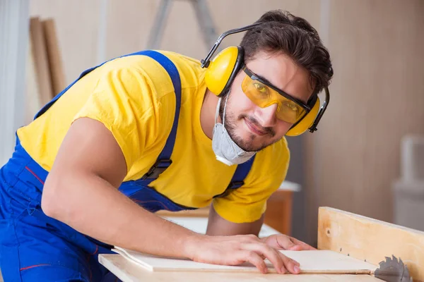 Genç bir marangoz dairesel testere ile çalışıyor.