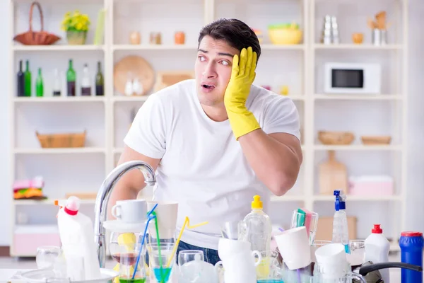 Чоловік розчарований необхідністю мити посуд — стокове фото