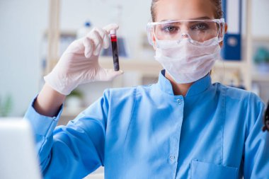 Bir laboratuarda deney yapan kadın bir bilim adamı.