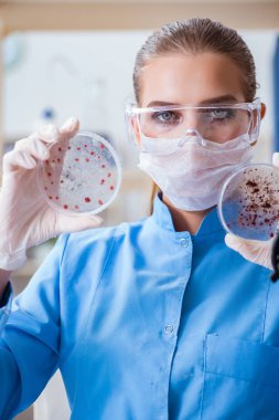Bir laboratuarda deney yapan kadın bir bilim adamı.