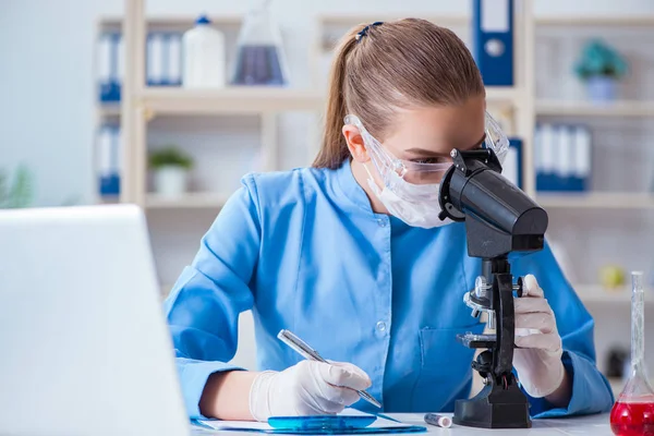 Bir laboratuarda deney yapan kadın bir bilim adamı.