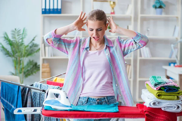 Droevige vrouw strijken kleding thuis — Stockfoto