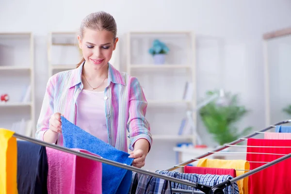 Genç ev hanımı evde çamaşır yıkıyor.