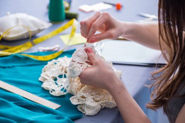 Kadın terzi dikiş dikmek için dikiş dikiyor.