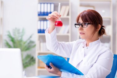 Bir laboratuarda deney yapan kadın bir bilim adamı.