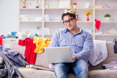 Genç adam dağınık bir odada çalışıyor.