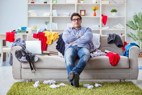 Junger Mann arbeitet in chaotischem Zimmer — Stockfoto