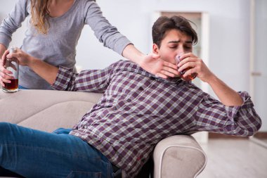 Genç bir aile kavramında içki sorunu yaşayan sarhoş bir koca.