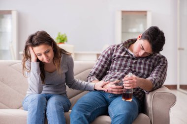 Genç bir aile kavramında içki sorunu yaşayan sarhoş bir koca.