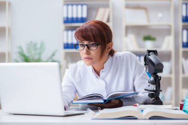 Bir laboratuarda deney yapan kadın bir bilim adamı.