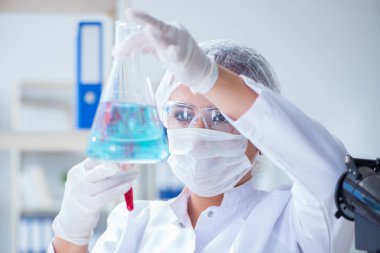 Bir laboratuarda deney yapan kadın bir bilim adamı.