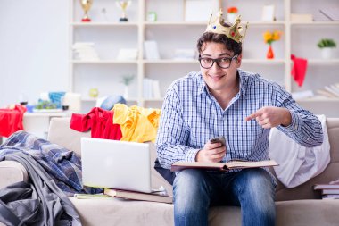 Genç adam dağınık bir odada çalışıyor.