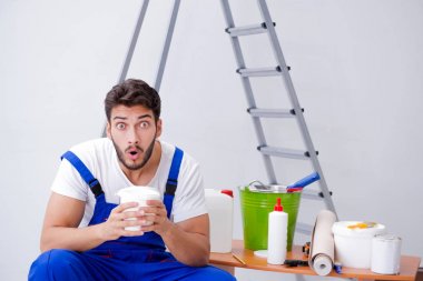 Tamirci, duvar kağıdıyla evde tadilat yapıyor.