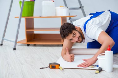 Adam evde duvar kâğıdı yenileme yapıyor.