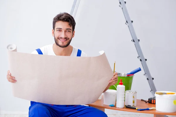 Reparador haciendo reparación de renovación en la casa con wallpa de papel — Foto de Stock