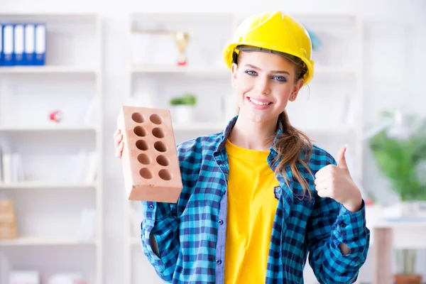 Mujer con ladrillo en concepto de construcción — Foto de Stock