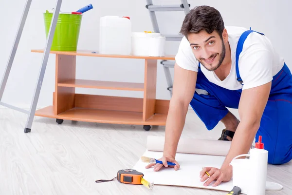 Reparatör gör renovering reparation i huset med papper wallpa — Stockfoto