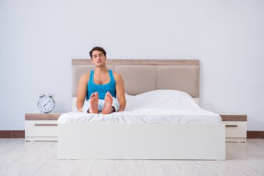 Genç adam yatakta uyanıyor.