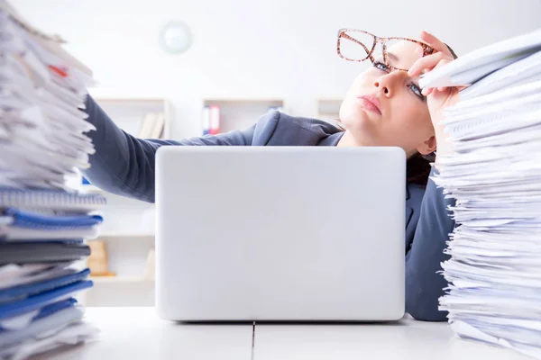 Tired businesswoman with paperwork workload