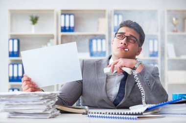 Ofiste sigara içen bir iş adamı elinde boş bir mesaj tutuyor.