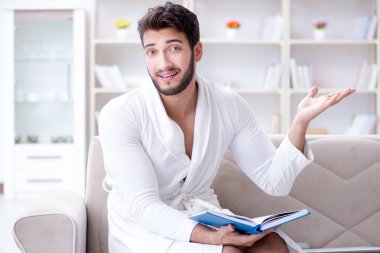 Öğrenci işadamı genç adam bir kitap okuyor.