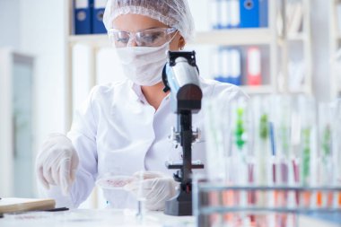 Bir laboratuarda deney yapan kadın bir bilim adamı.