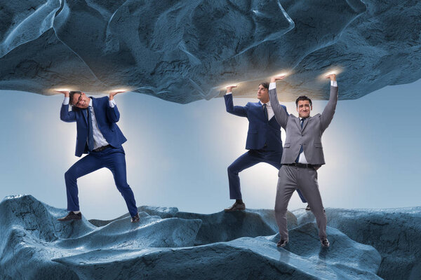 Бизнесмен, поддерживающий камень под давлением