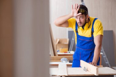 Genç bir marangoz dairesel testereyle odun kesiyor.