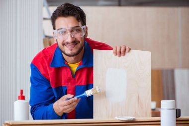 Yooung marangoz boyayla uğraşıyor.