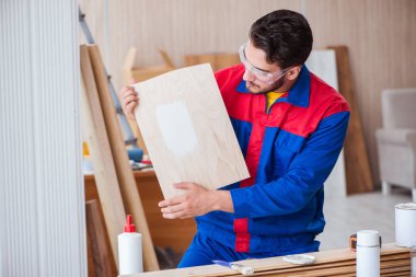 Yooung marangoz boyayla uğraşıyor.