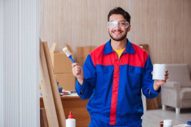 Yooung marangoz boyayla uğraşıyor.