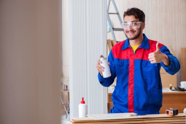 Yooung marangoz boyayla uğraşıyor.