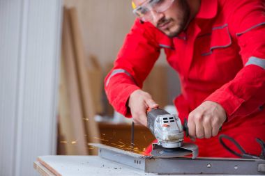 Öğütücü tekerlekle çalışan genç bir tamirci