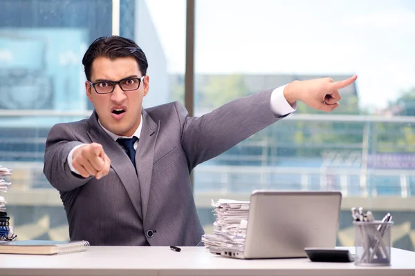 Angry businessman with too much work in office