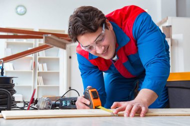 Genç marangoz ahşap kalaslarla çalışıyor.