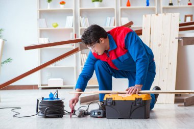 Genç marangoz ahşap kalaslarla çalışıyor.